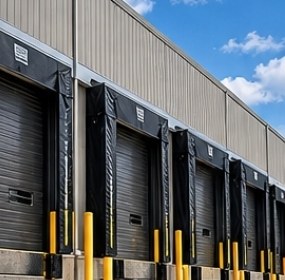 Row of loading dock doors with dock seals and yellow safety bollards