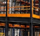 Steel mezzanine with orange railings over pallet racking